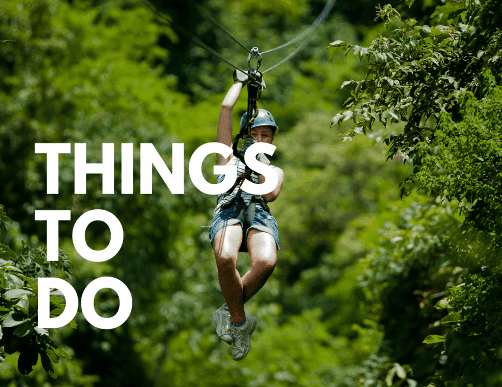 Child ziplining through rainforest canopy representing things to do in Costa Rica