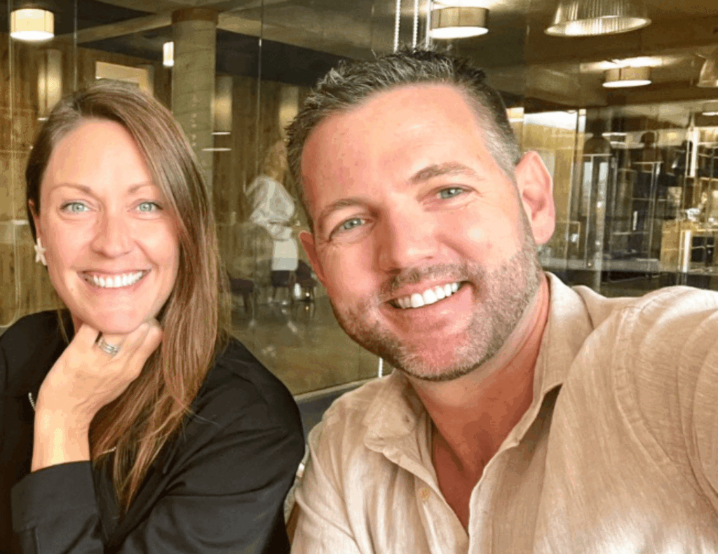 Nick and Dariece from Goats on the Road smiling indoors — top digital nomad and long-term travel blog for couples and families.