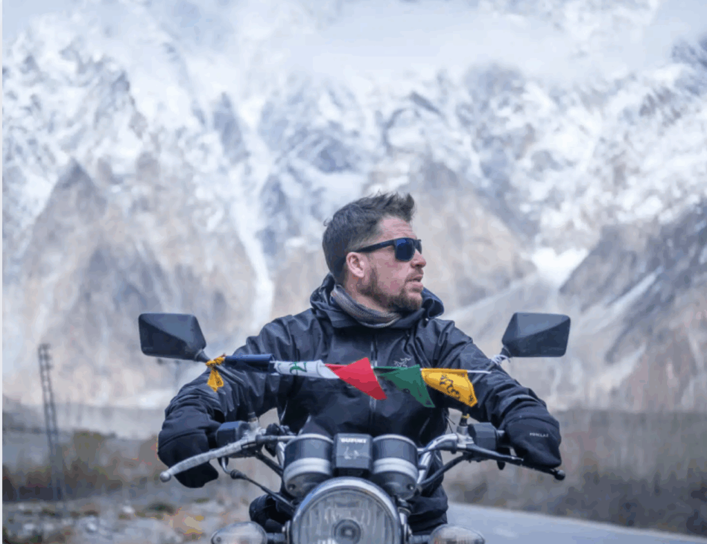 Will from The Broke Backpacker riding a motorcycle through a mountain pass — one of the best blogs for adventure and extreme budget travel in 2025.
