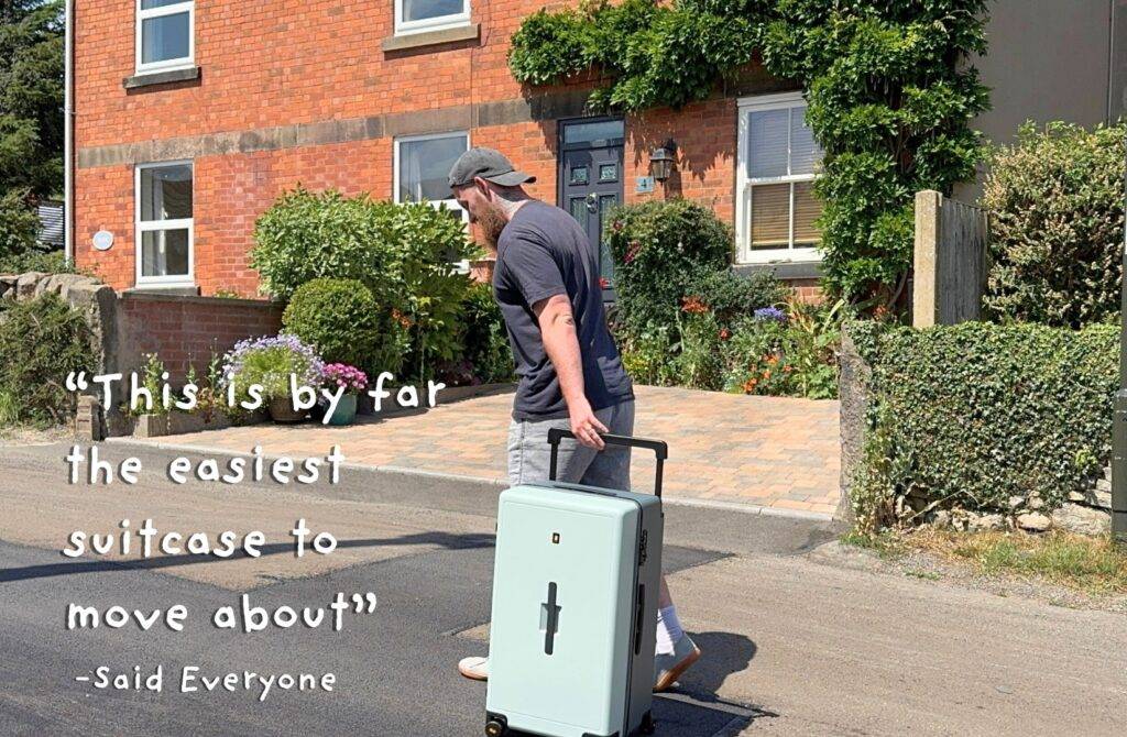 Dad pulling mint green suitcase on quiet neighborhood street