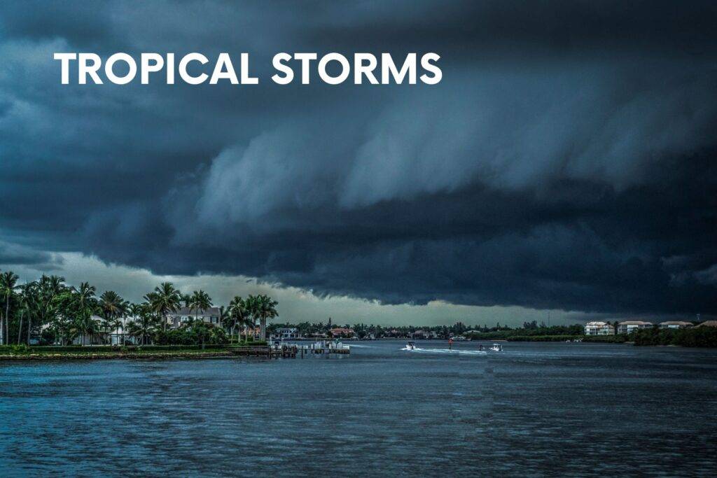 Dark storm clouds over coastal town—tropical storm/hurricane precautions for families.