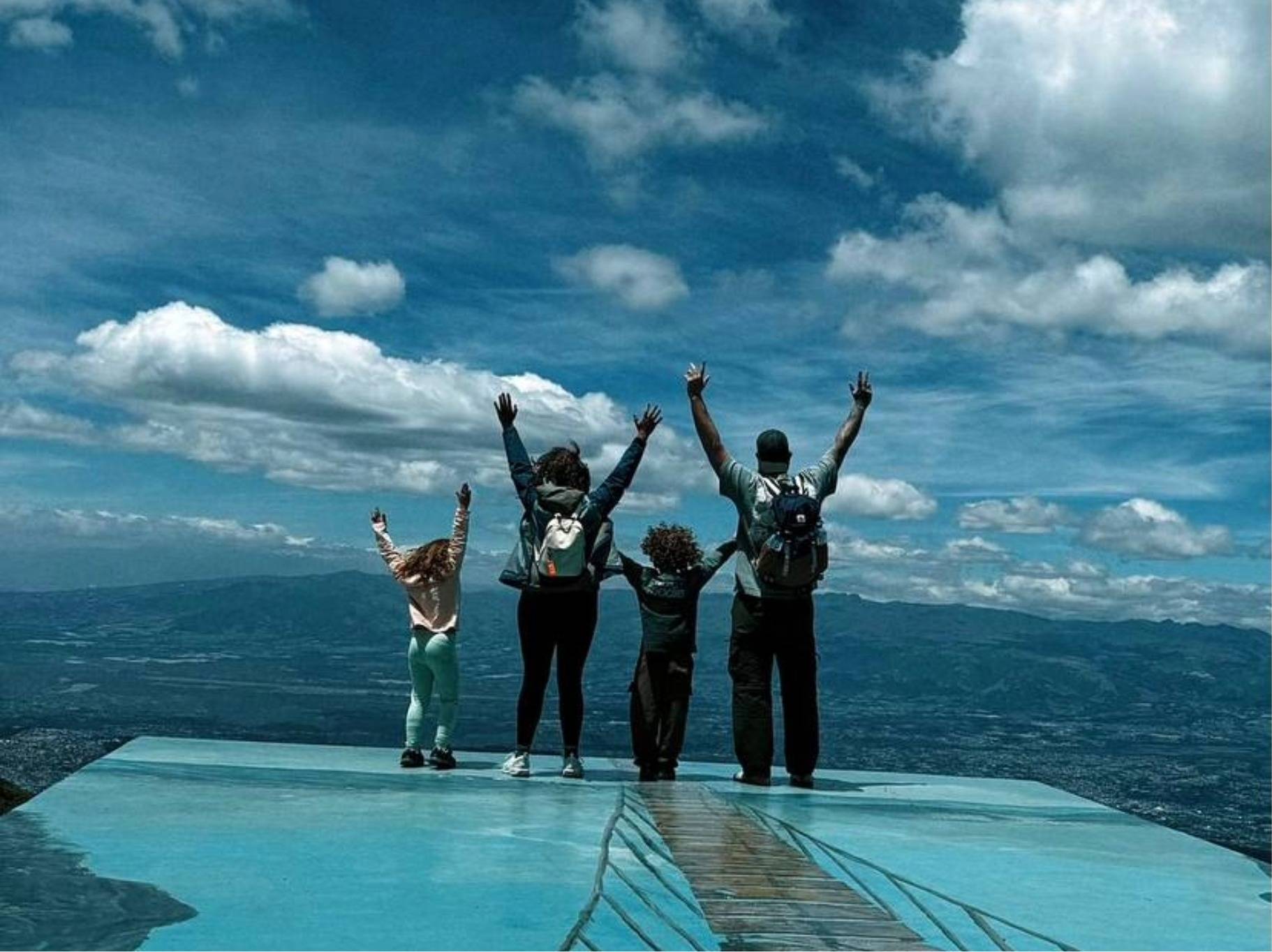 Family of four in Quito raising their hands