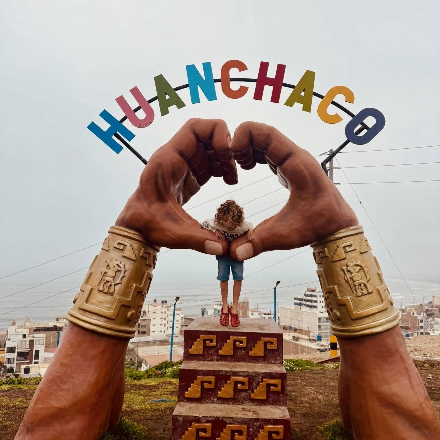 Kid standing on monument in huanchacho