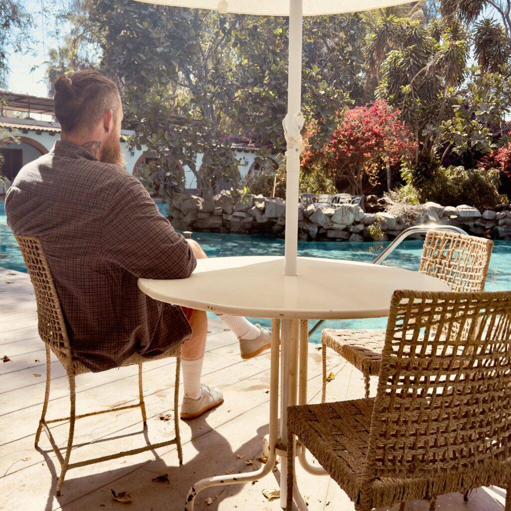 Man sitting with a coffee near a lake