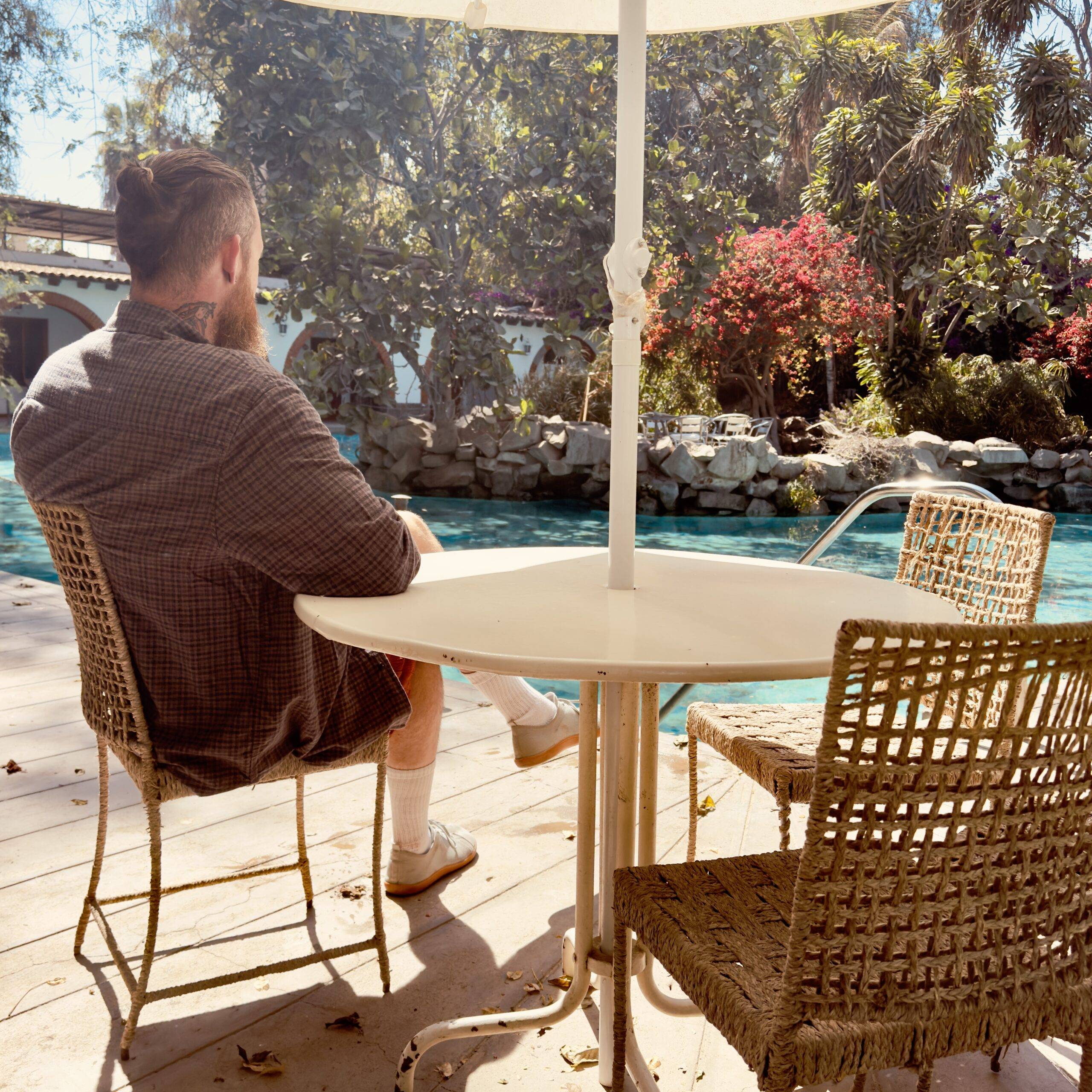 Man sitting with a coffee near a lake